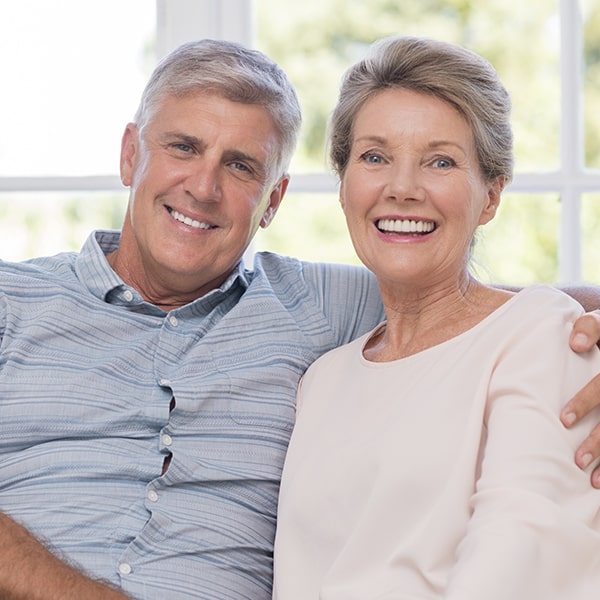 Senior couple with dental implants smiling